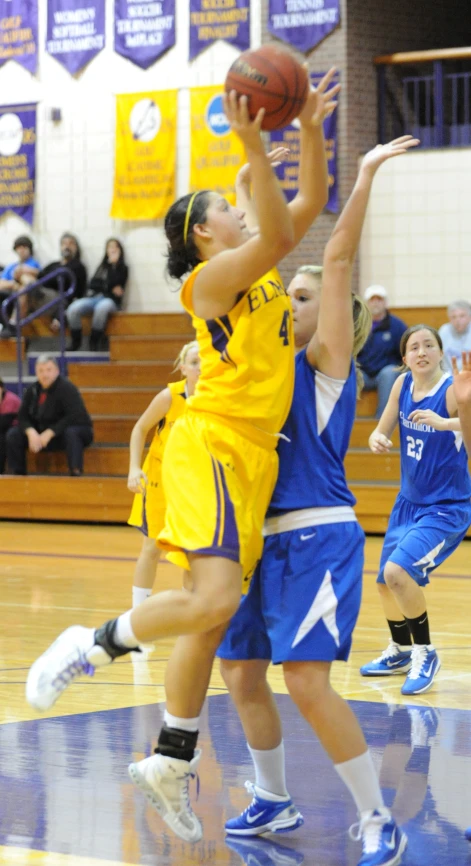 the girls are in action playing basketball on the court