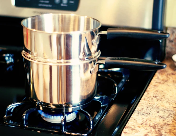 a silver pot sitting on top of a stove