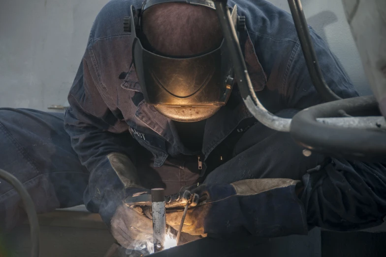 a man wearing a welding gear and holding an iron bar