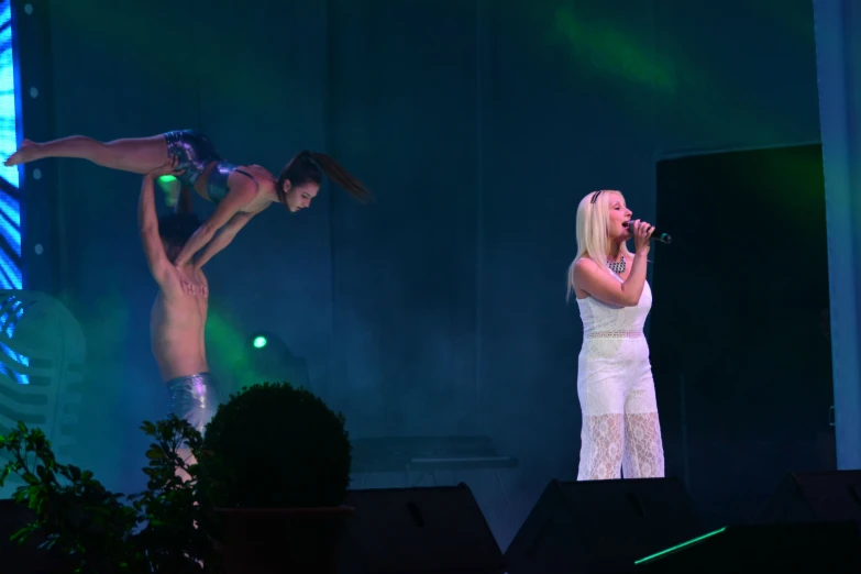 two women in white on stage performing on a stage