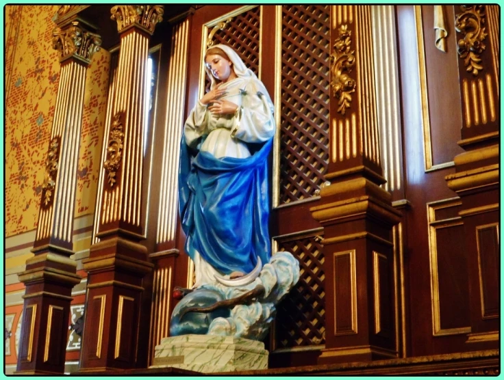 statue of a woman holding a child in front of ornate pipes