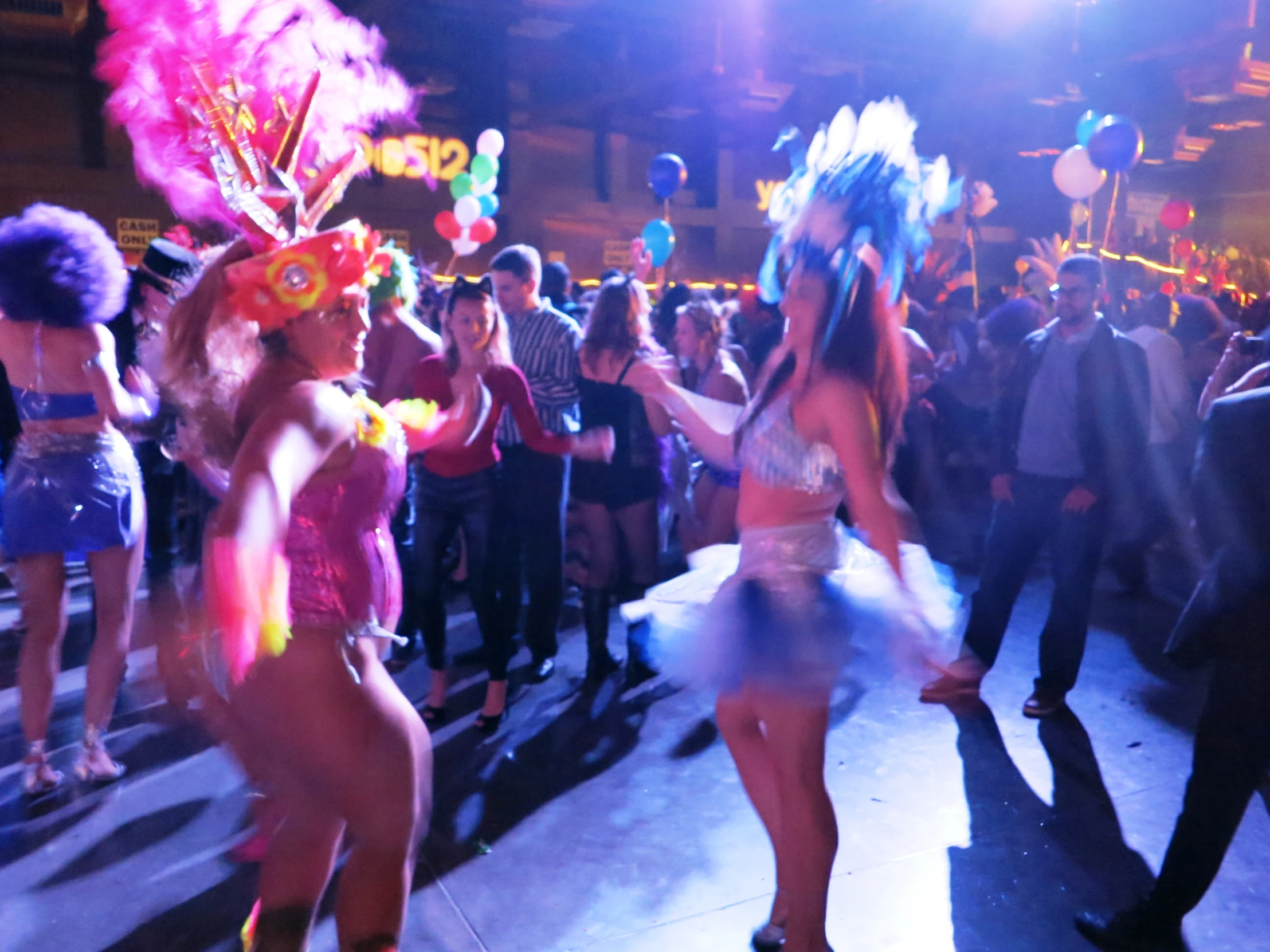 two women wearing elaborate costume dancing in a nightclub