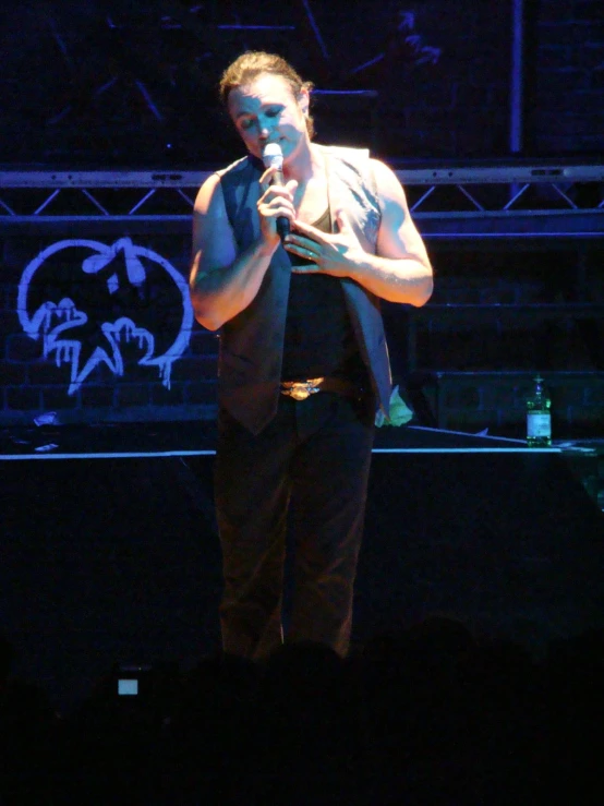 a man standing on top of a stage holding a microphone