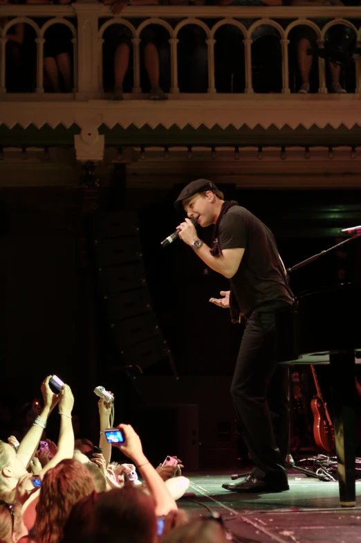 a man singing and a group of people clapping