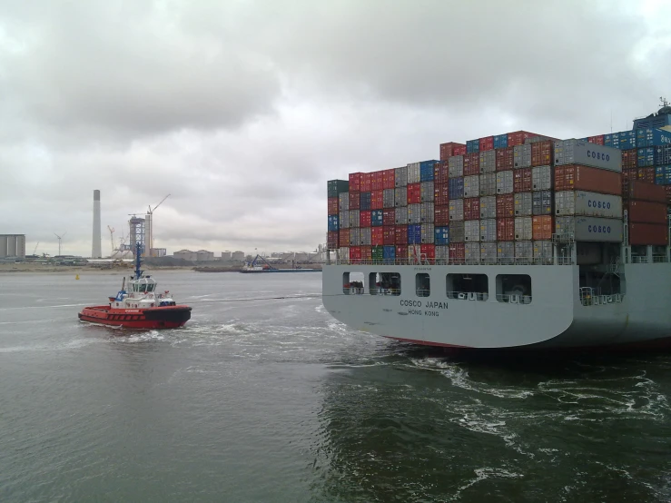 a large cargo ship passing a smaller ship