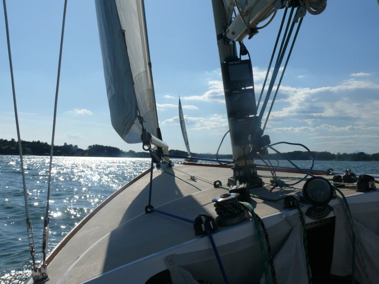 a sail boat on the water near the sun