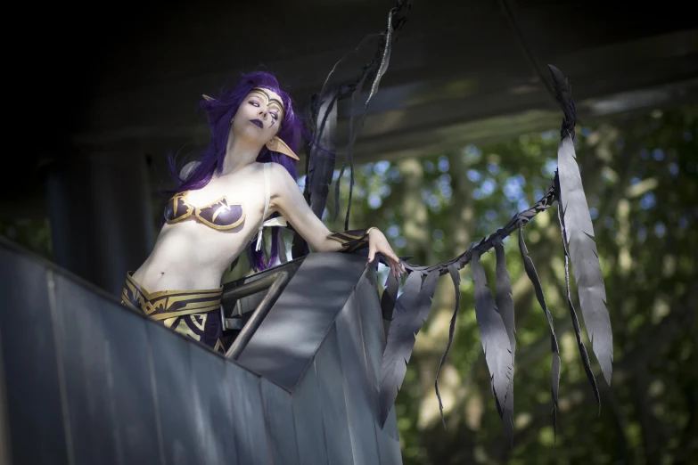 a girl dressed in elaborate clothing sits on top of a metal wall