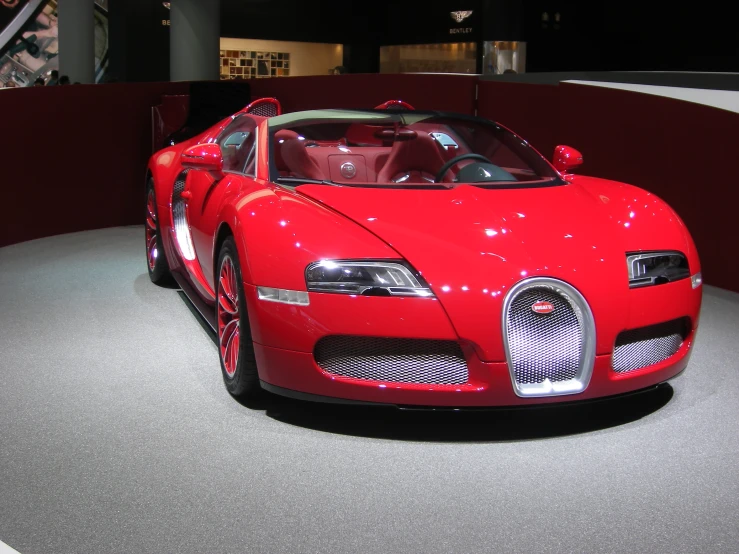 a very nice red car on display in the room