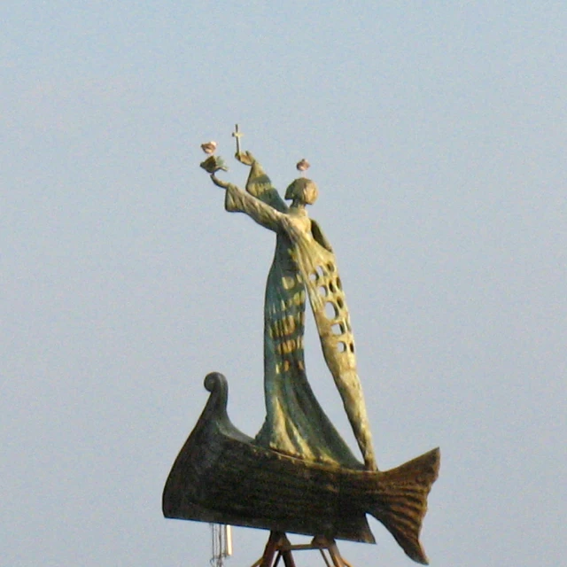 a statue is standing on top of a clock tower