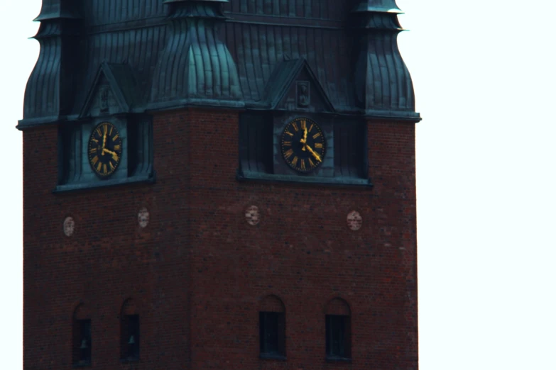 a brick tower with two clocks on each side