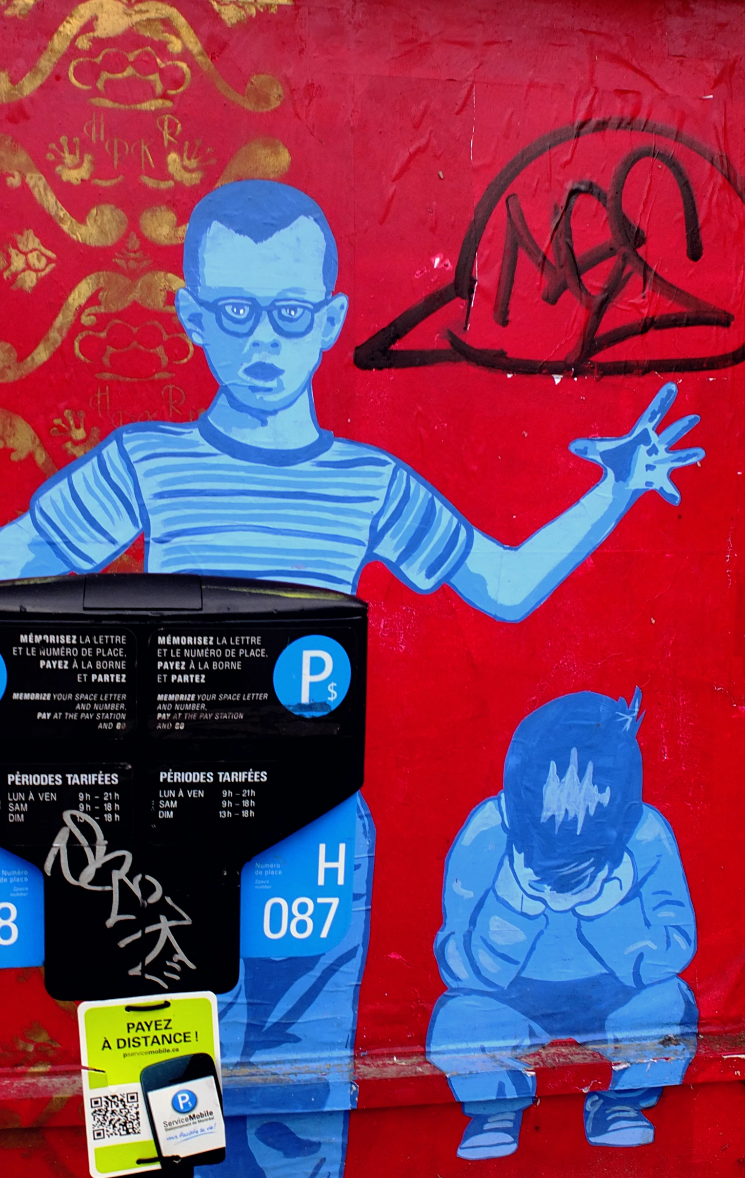 a man pointing at some blue graffiti on a red wall