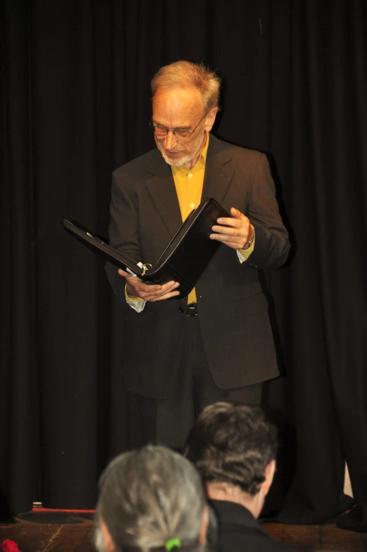 a man is wearing a suit and yellow tie