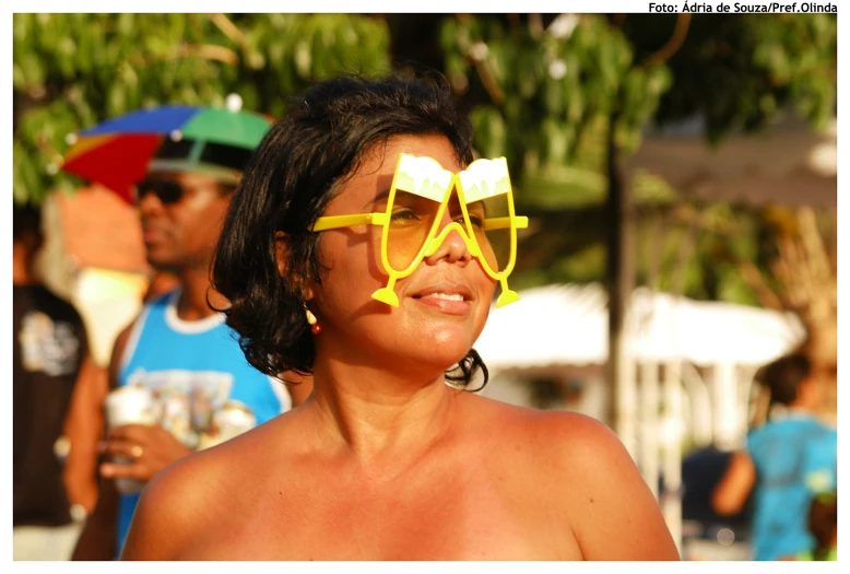 a lady that has yellow sunglasses on and she is smiling