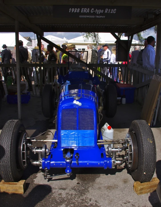 a blue car on wheels sitting in a garage