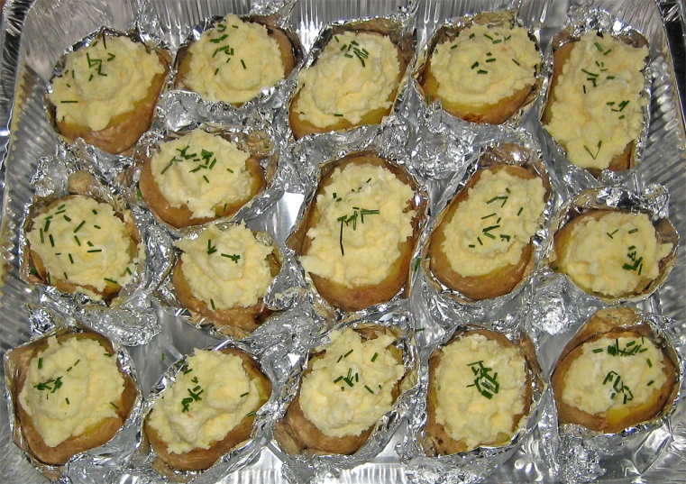 a baking pan filled with potatoes covered in cheese