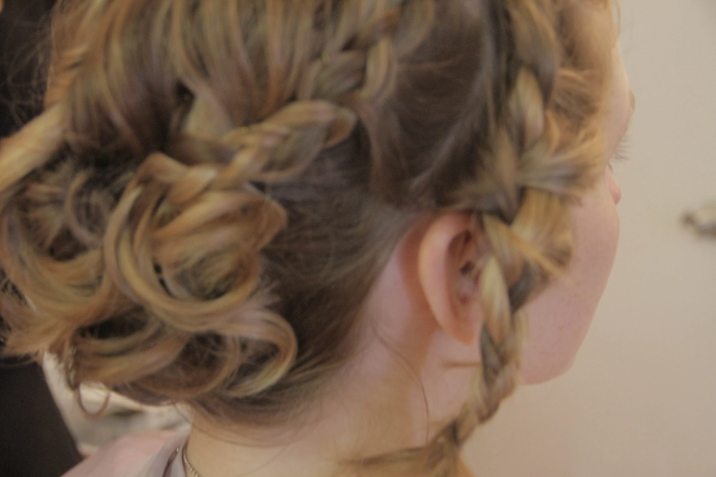 a woman is iding her hair in to a bun