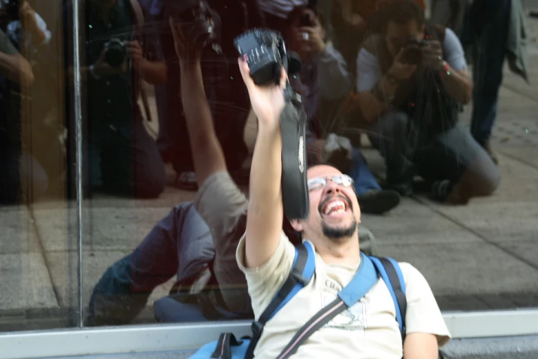 a man smiles as he takes his po with his phone