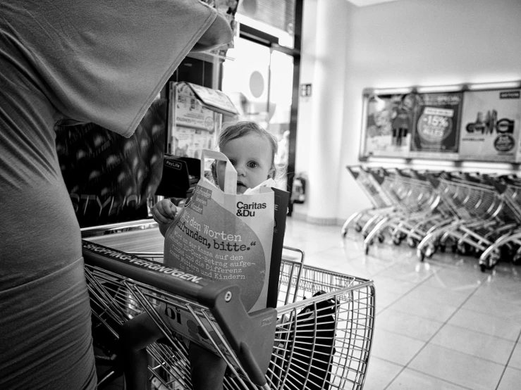 a boy sitting inside of a shopping cart