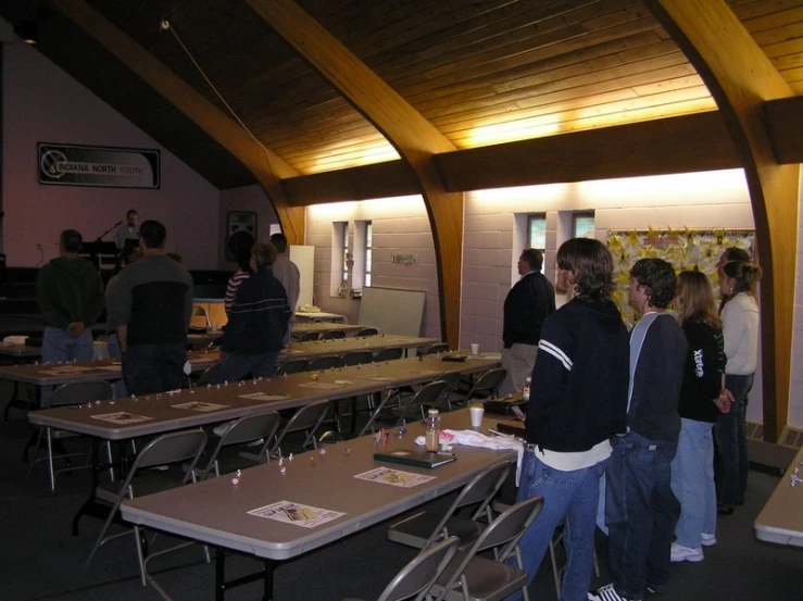 several people standing around tables in a room