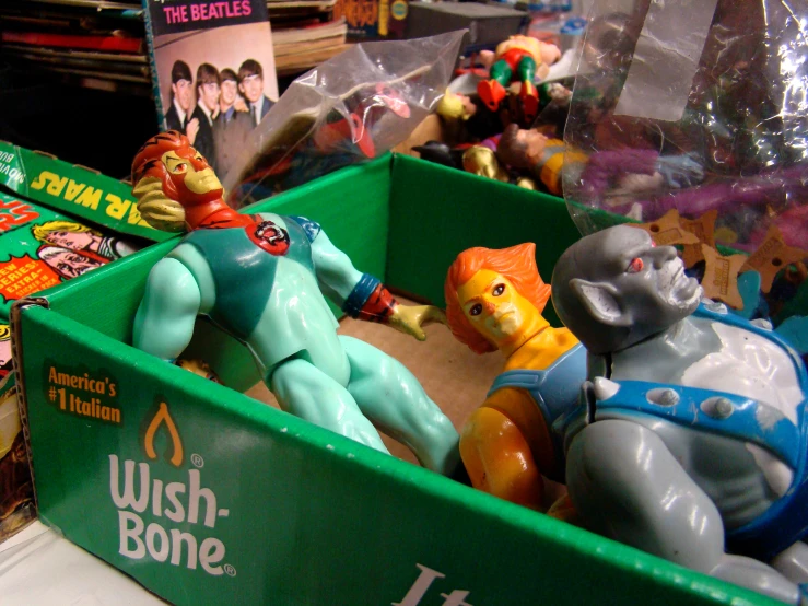 toy action figures inside a green plastic crate