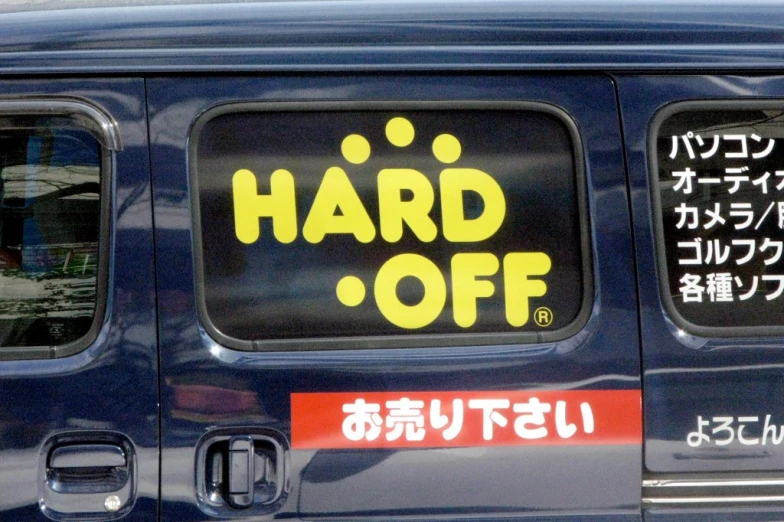 a van parked on the street that has a sign reading hard off