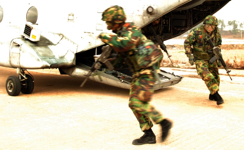 a military man carrying a bag to a plane