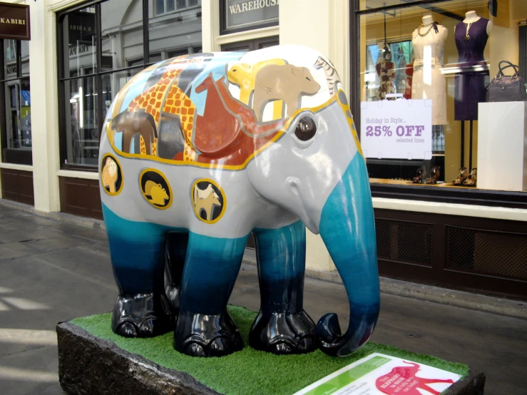 a small toy elephant statue standing outside of a store