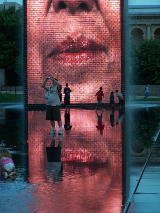 a large screen with many people standing around