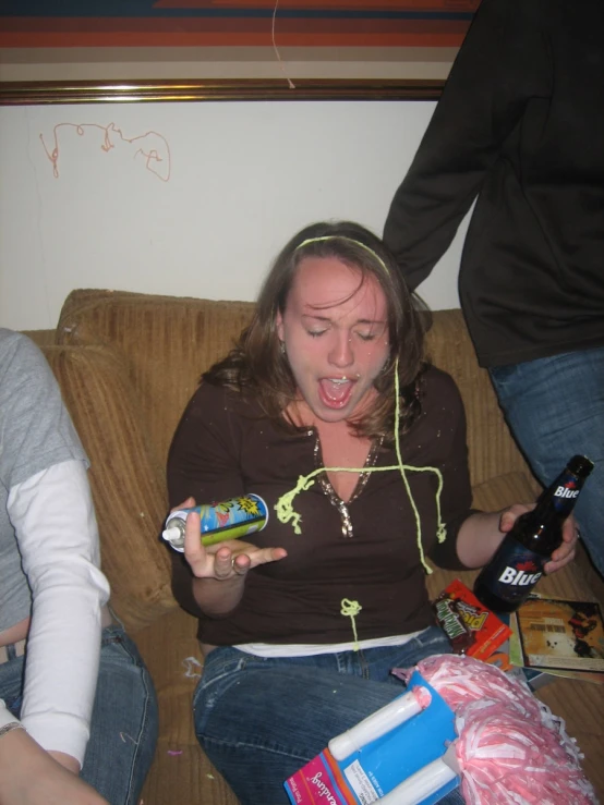 the woman is drinking while sitting on a coach