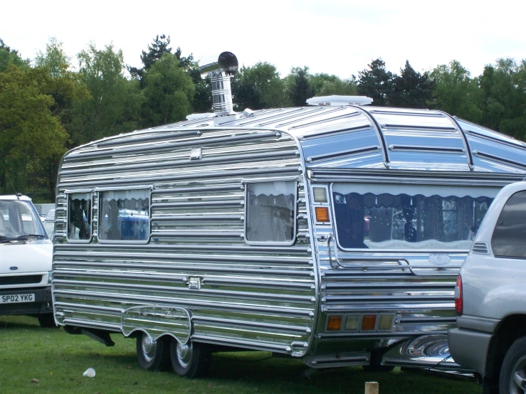 two cars parked on grass and a camper