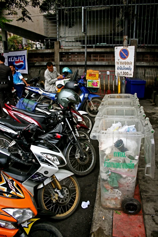 the people are standing around a number of motorcycles