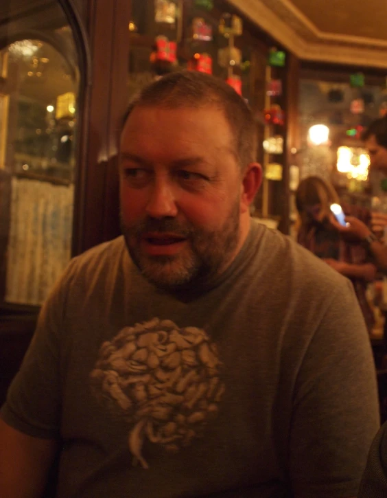 two men are sitting in a bar with a woman