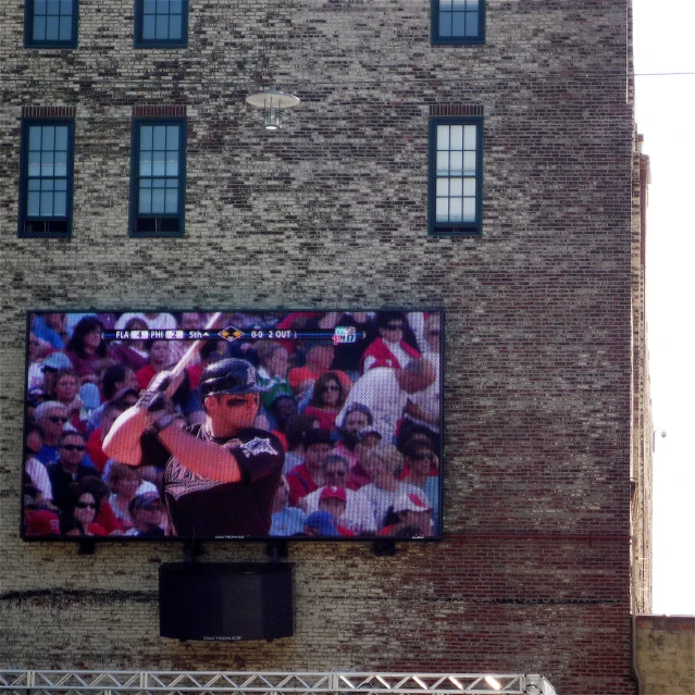 a tv screen with several pieces of colored plastic on the side of a building