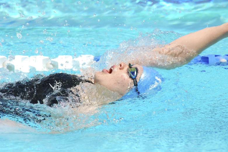 an outdoor pool with a swimmer in action