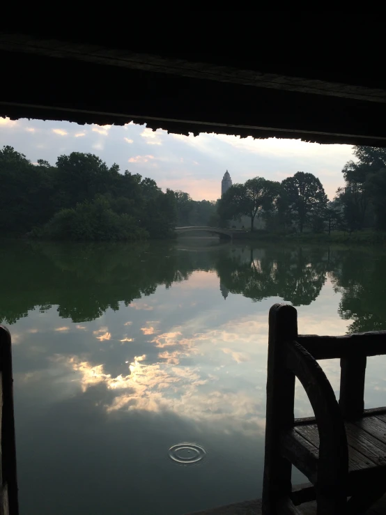 the sun is setting over a calm pond