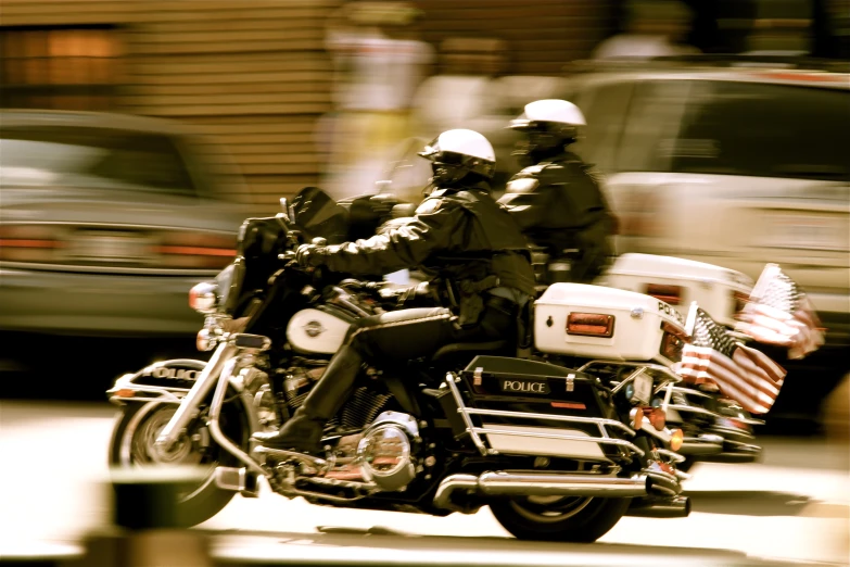 two police officers on a motorcycle riding through the street