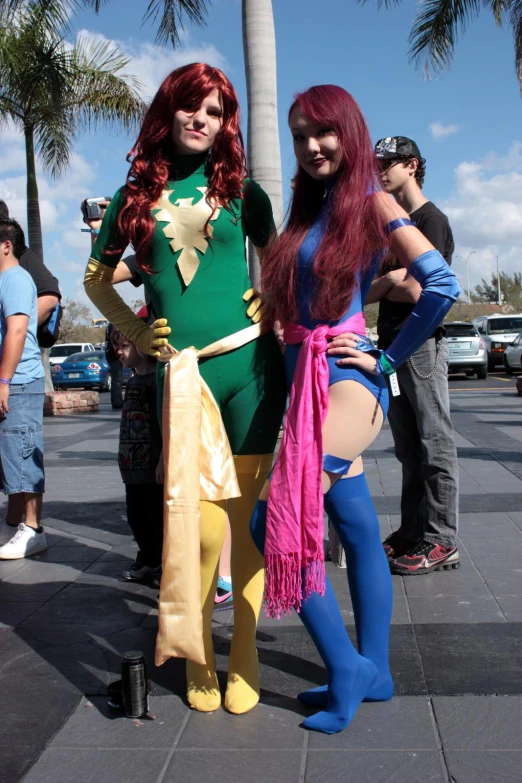 two women in costumes on a sidewalk next to trees