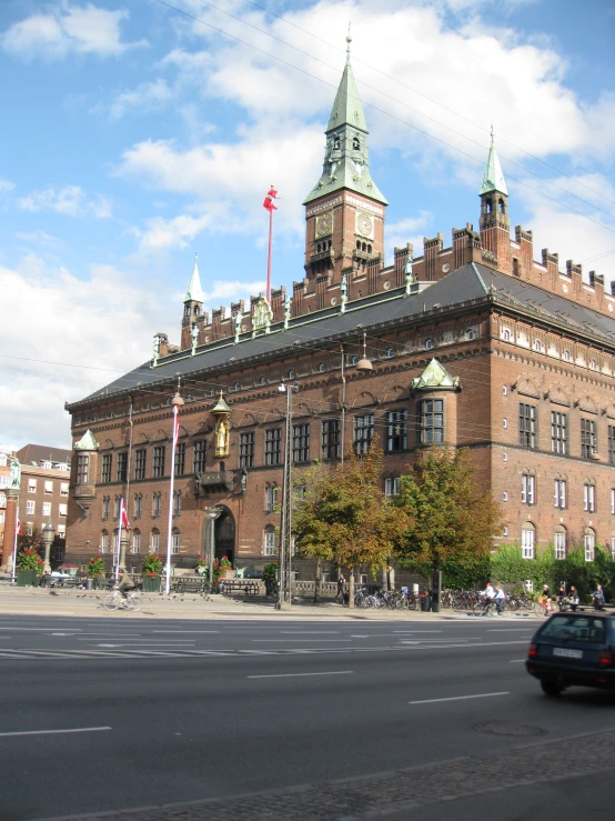 a car drives on a road past a building with large towers