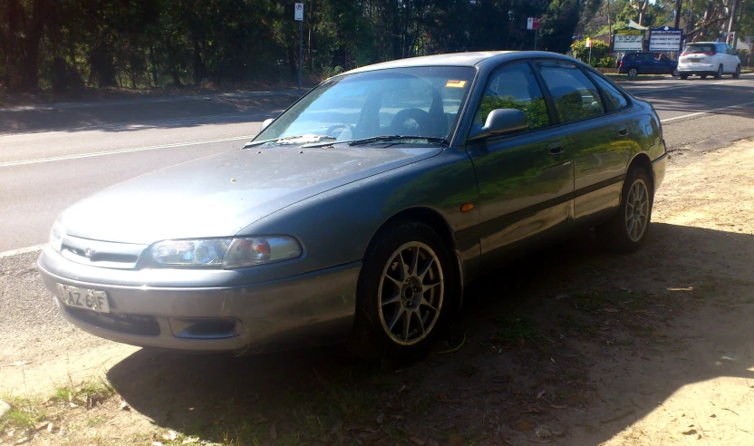 the silver car is parked on the side of the street