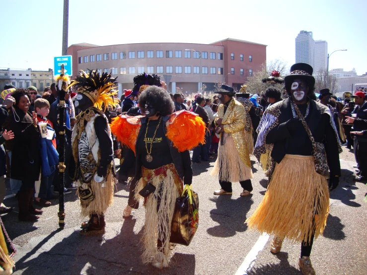 a large crowd walking in the street with costumes