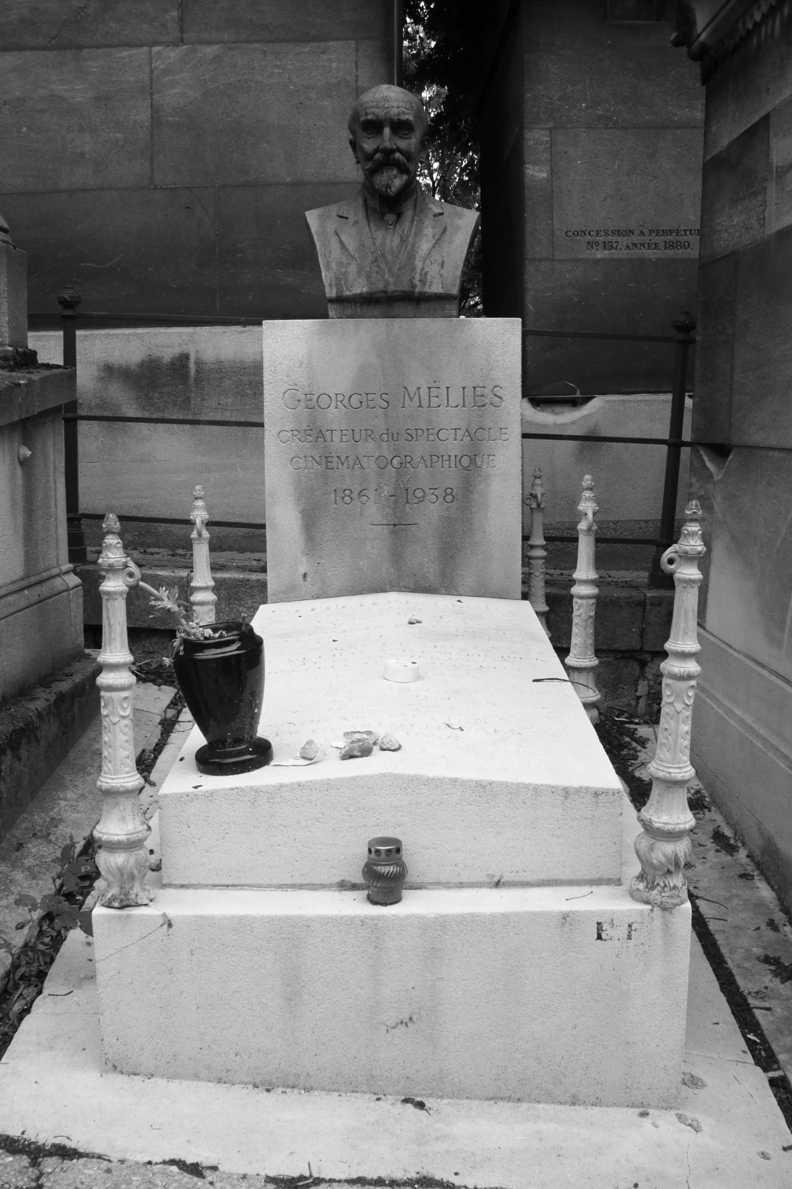 a black and white po of a busturine, potted plant, and cemetery steps