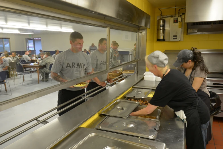 people are in the kitchen at the army service