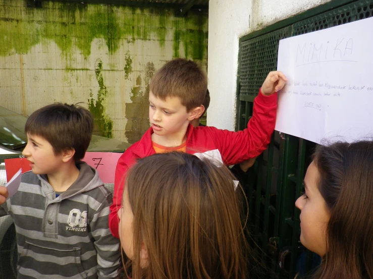 the boy is holding up his notes outside