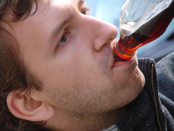 man with red wine in mouth staring ahead