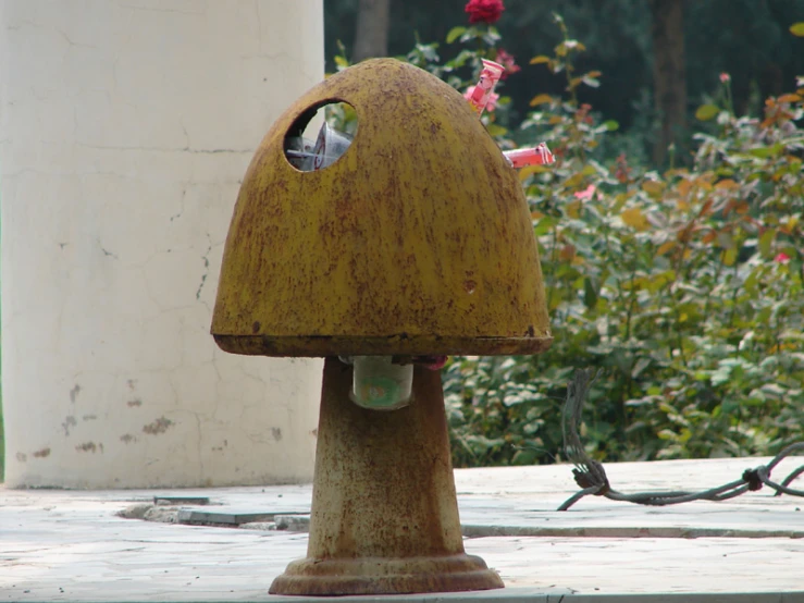 a metal object with one light shining and trees in the background