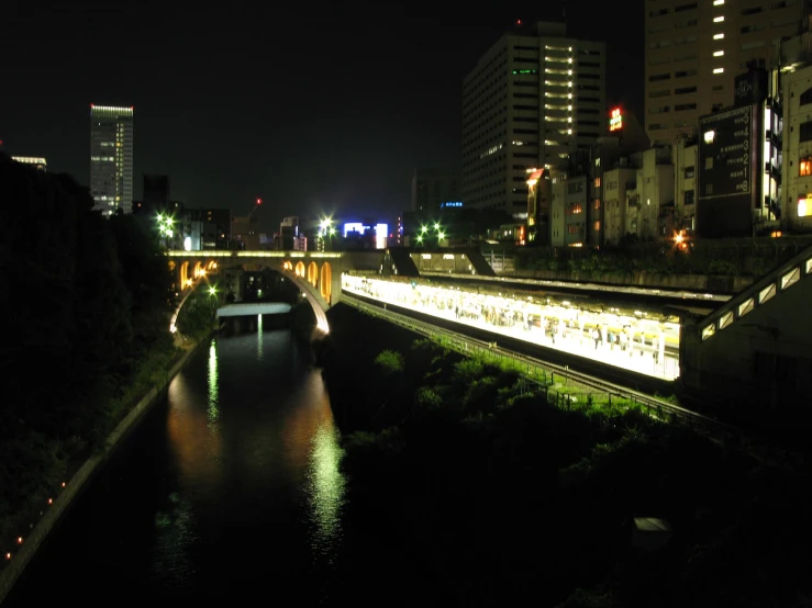 a city scene with focus on the river and the bridge