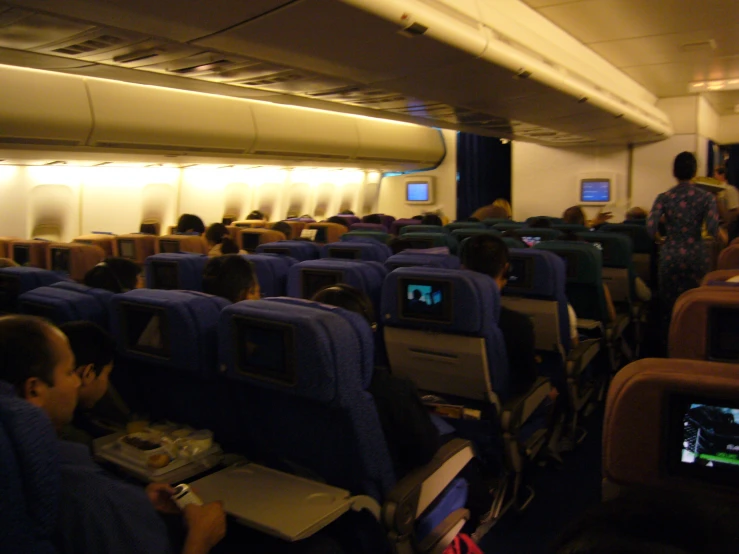 passengers are on a large airplane using laptops