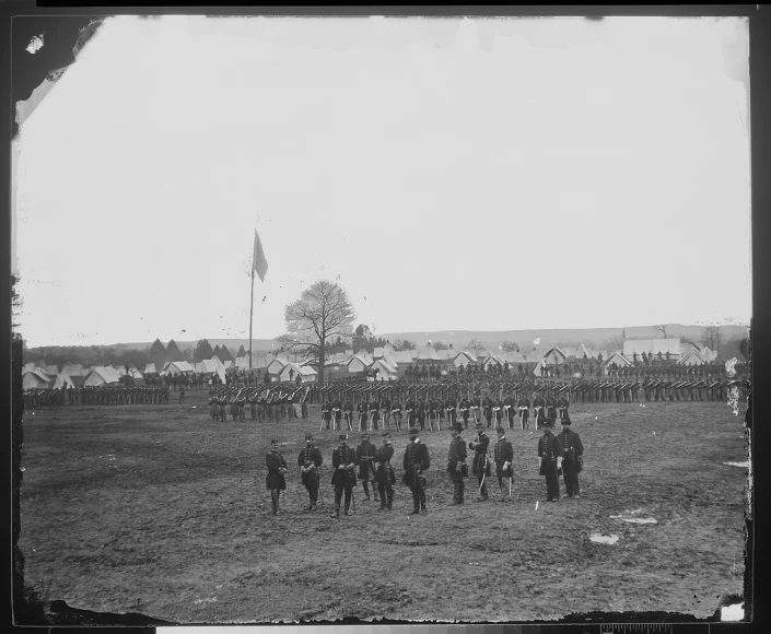 a group of people standing around each other in the grass