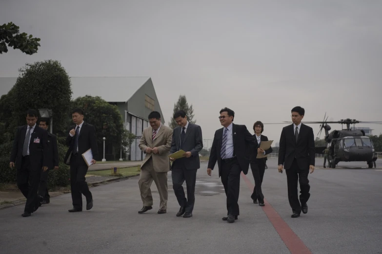 men in suits and ties walking on the side walk of the street