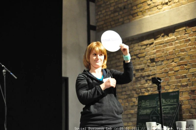a woman in black sweater holding a white disc